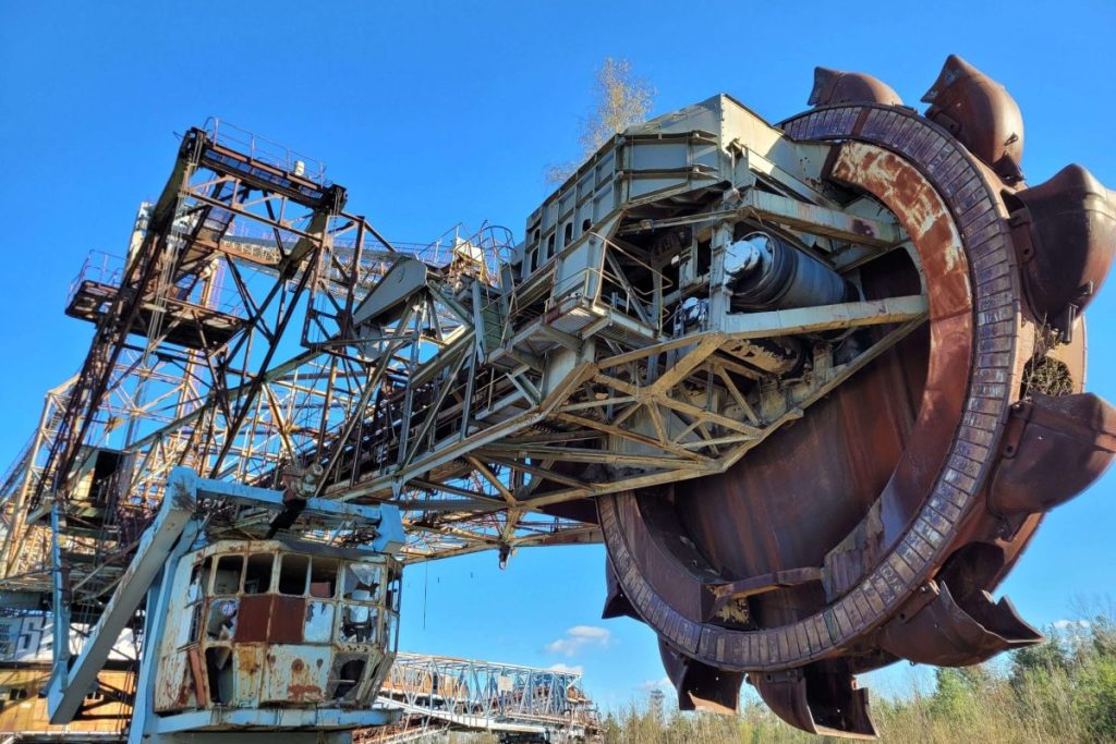 A closeup of a bucket-wheel excavator Bagger in a reen field under the clear sky